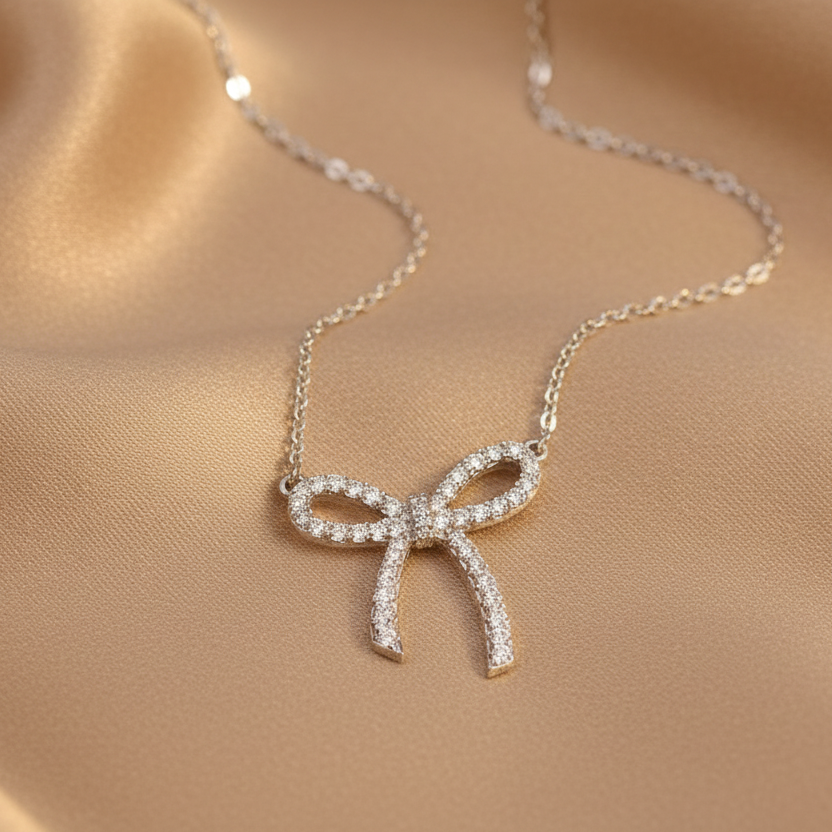 Necklace with a bow-shaped pendant on a beige fabric background