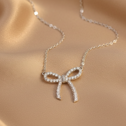 Necklace with a bow-shaped pendant on a beige fabric background